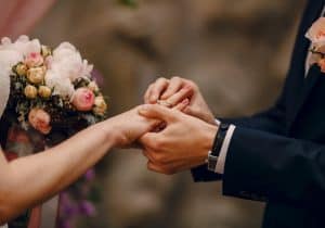 Groom putting the wedding ring on the bride's hand